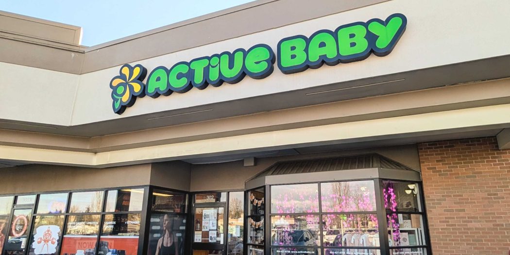 Active Baby's bright green sign above its glass-fronted corner store on 200 Street