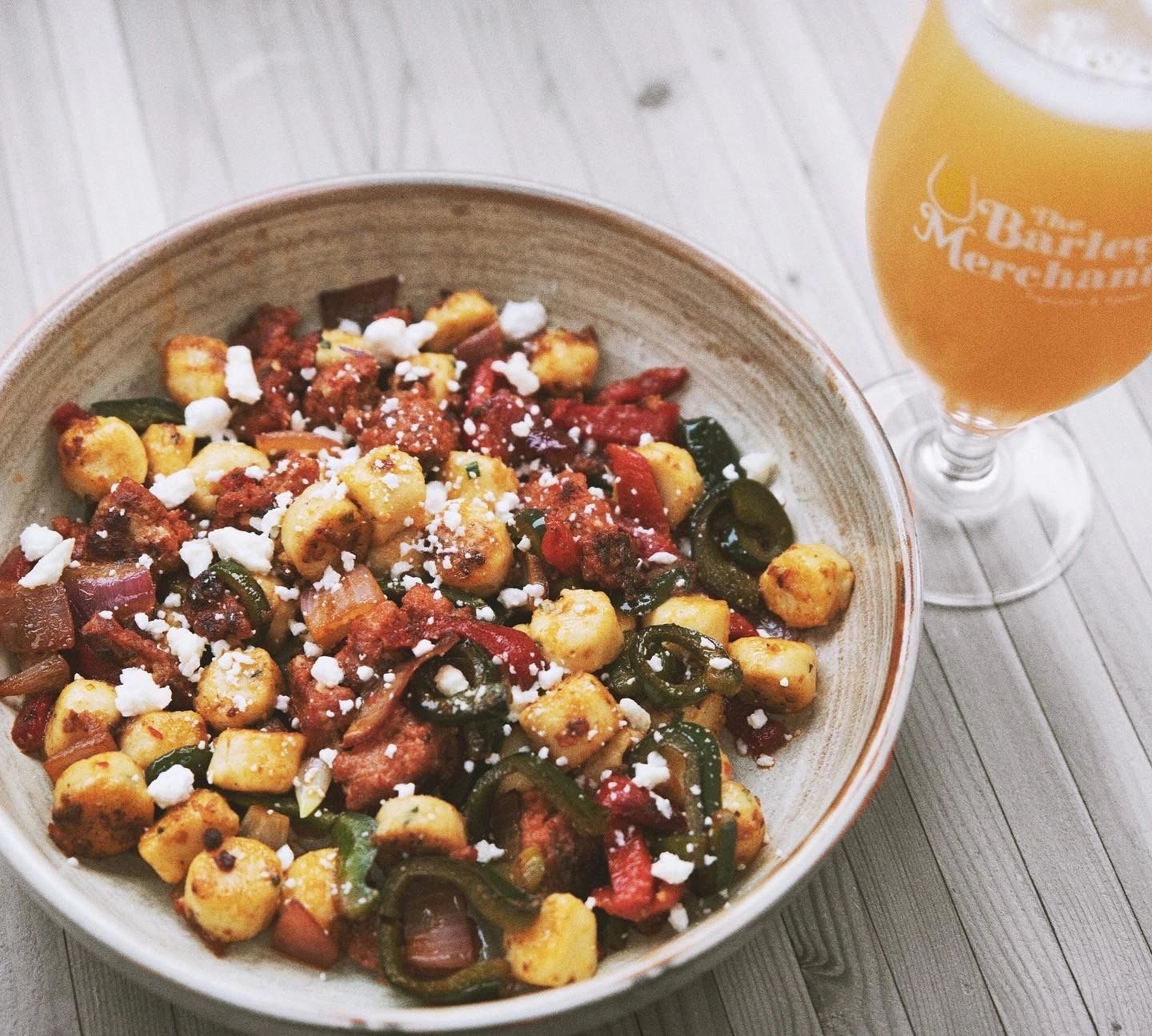 A bowl of gnocchi with peppers, jalapeños and crumbled cheese at The Barley Merchant