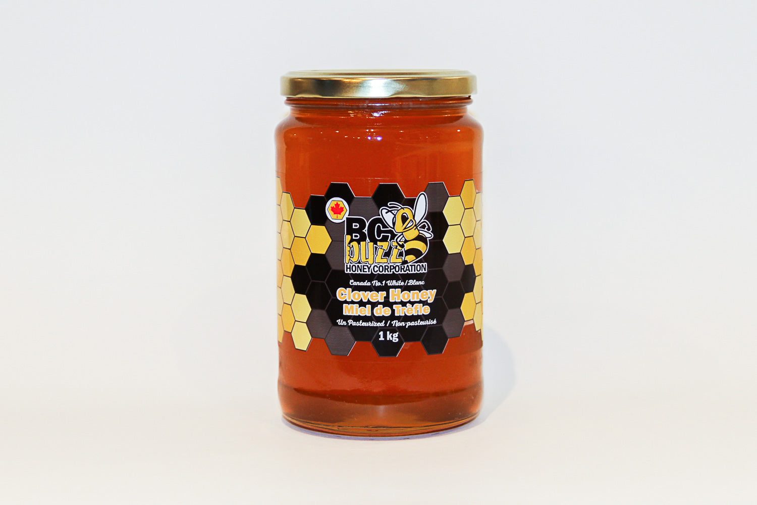 A 1 kg jar of BC Buzz clover honey with its black and gold honeycomb label
