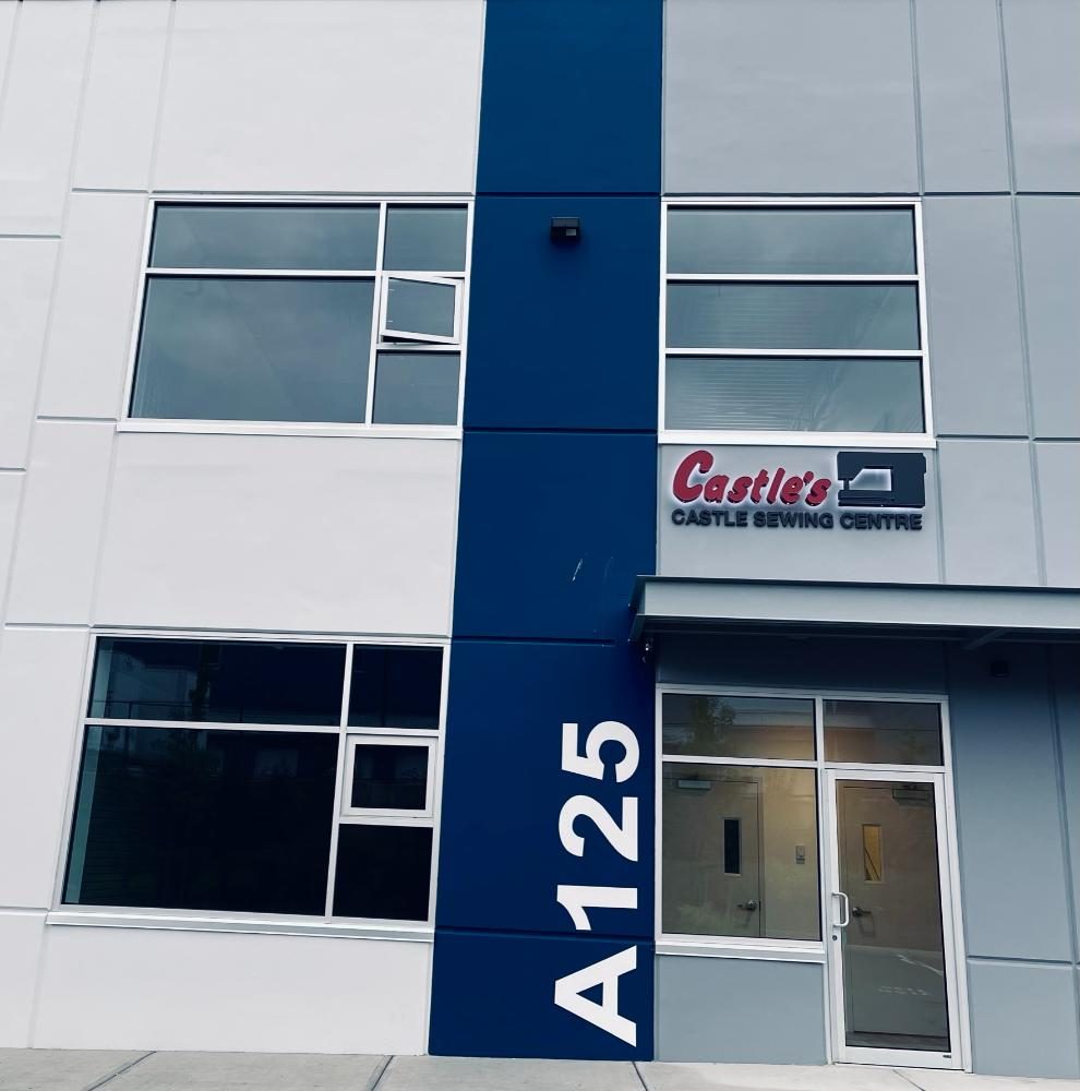 The Castle Sewing Centre sign above unit A125, a glass door in a navy and grey commercial building on 86 Avenue