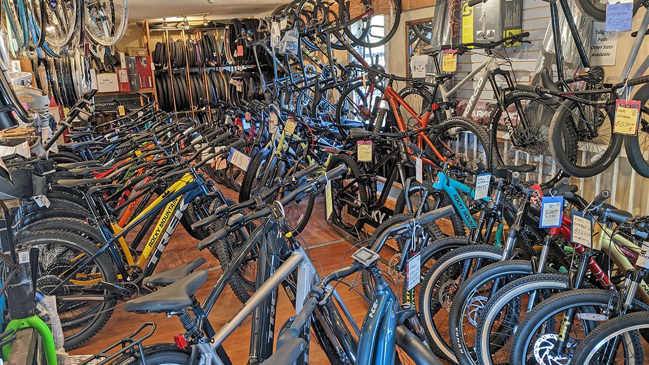 Rows of bikes packed into the Cranky's Bike Shop showroom, with tires and parts hanging along the walls