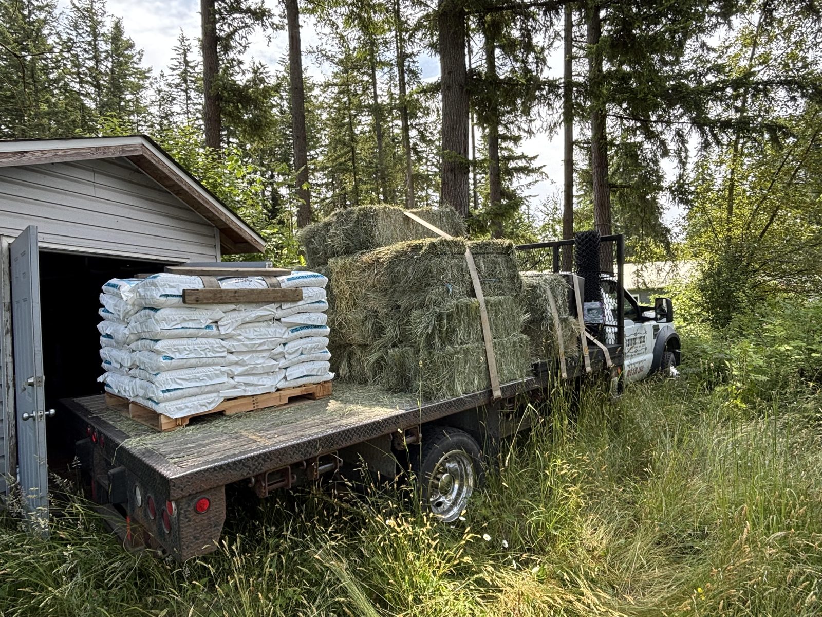 A Dare's flatbed delivery load of hay bales and bagged animal bedding
