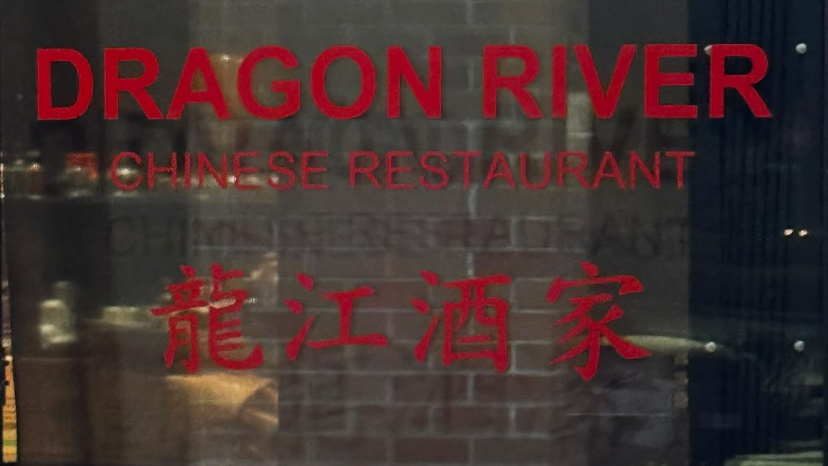 Red window lettering reading Dragon River Chinese Restaurant, with the restaurant's Chinese name below