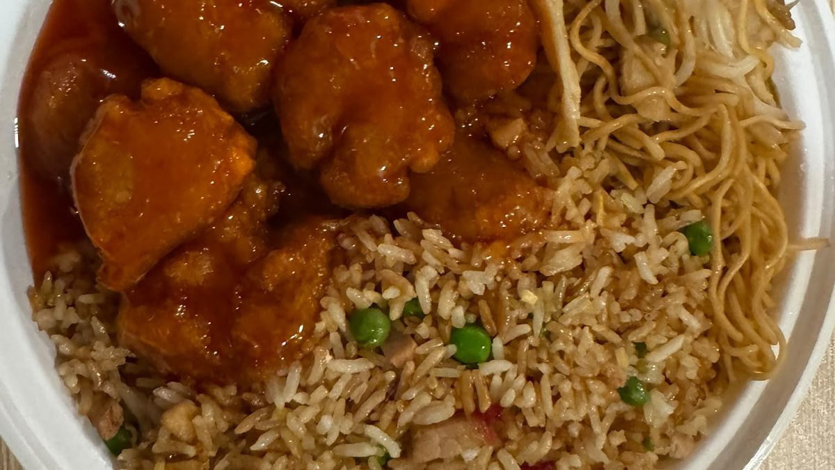 Chicken in a glossy red sweet-and-sour sauce beside fried rice with peas and BBQ pork, and chow mein