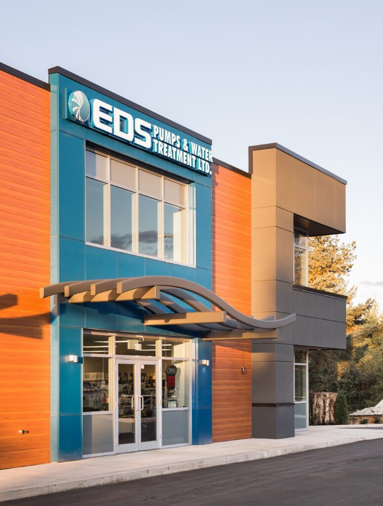 The EDS Pumps & Water Treatment building on Fraser Highway, with orange and blue cladding and a glass entrance