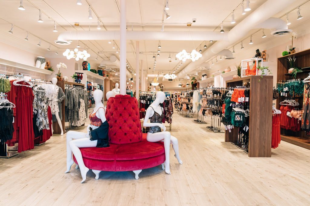 Inside Forever Yours Lingerie in downtown Langley: a bright, wide shop floor with a red velvet bench, racks and wood display walls