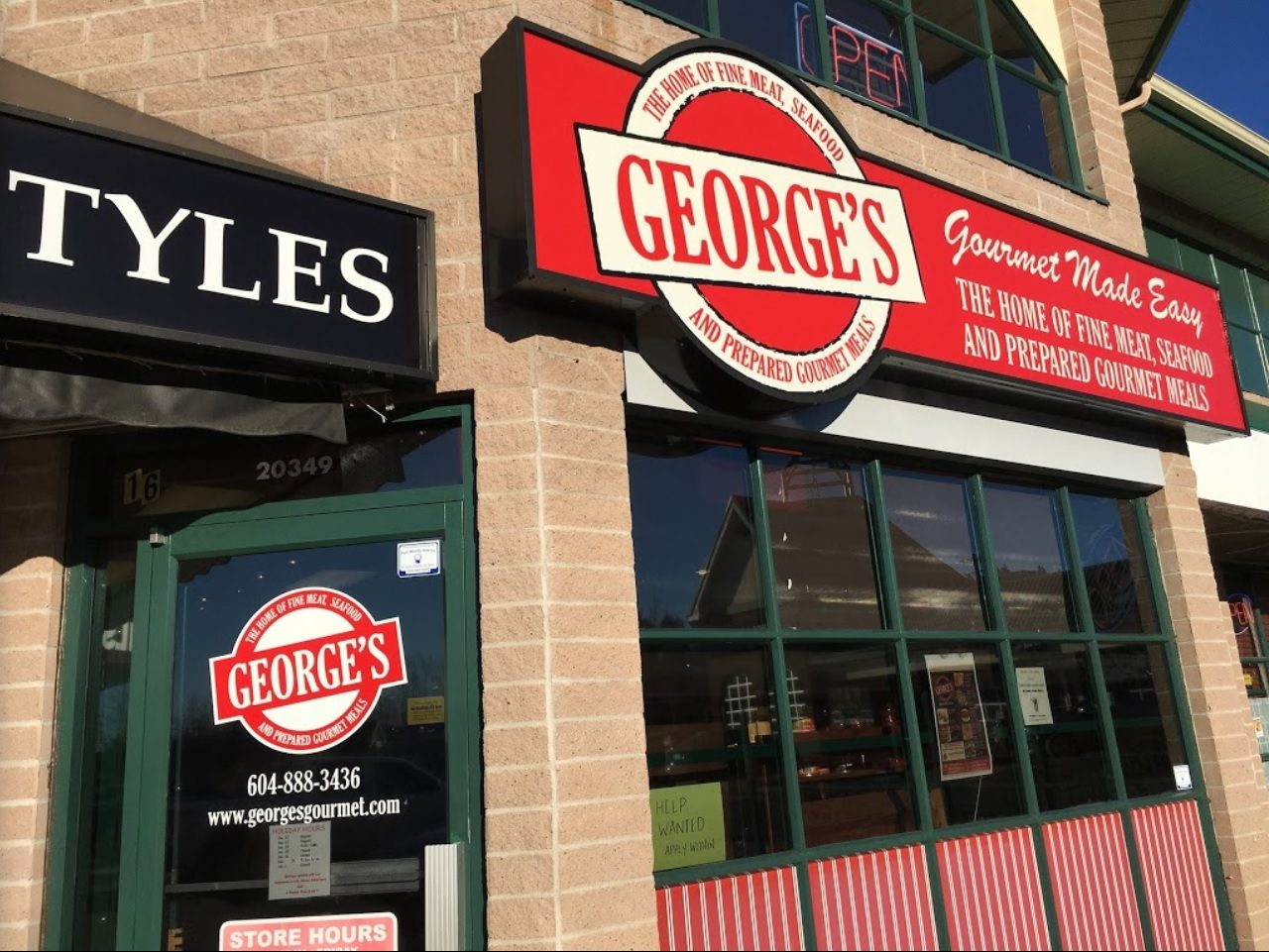 The front of George's Gourmet Meats in Walnut Grove: a red George's sign over green-framed windows and the shop door