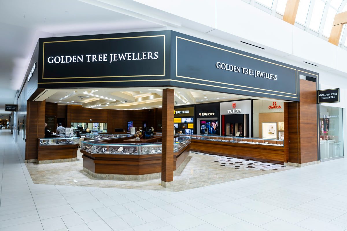Golden Tree Jewellers' corner showroom inside Willowbrook Shopping Centre, with long glass display counters and watch brand signs