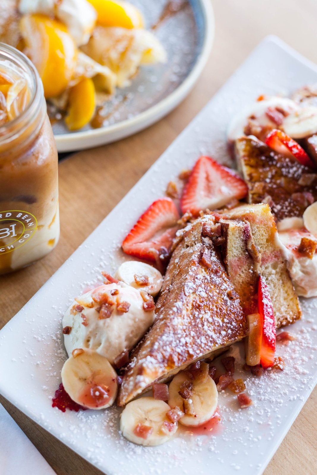 French toast with strawberries, banana, whipped topping and a dusting of icing sugar