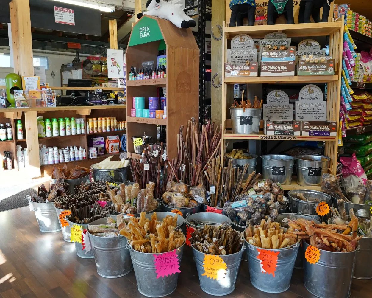 Inside Milner Feed: pet supplement shelves above galvanized buckets full of dog chews and treats
