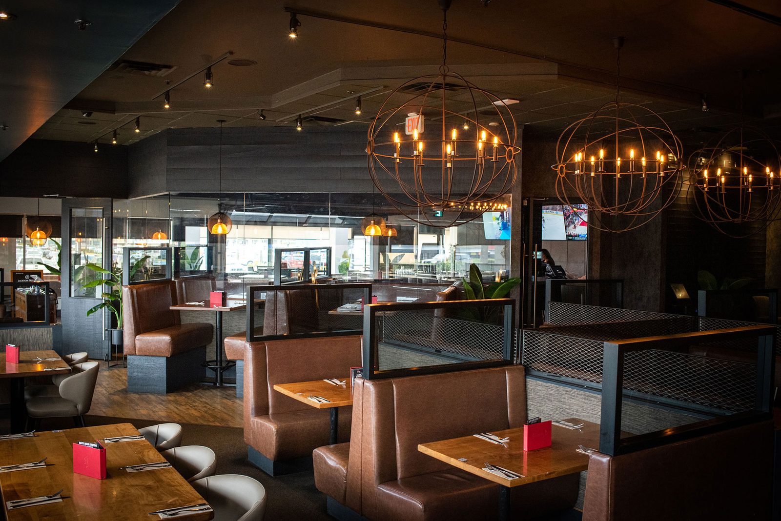 Inside Sammy J's Langley: leather booths, wood tables and round wrought-iron chandeliers