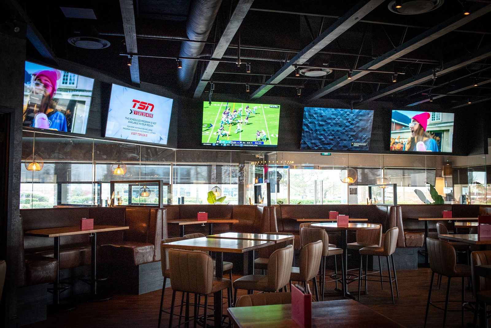 The dining room at Sammy J's Langley, with booths, high-tops and big screens along the windows