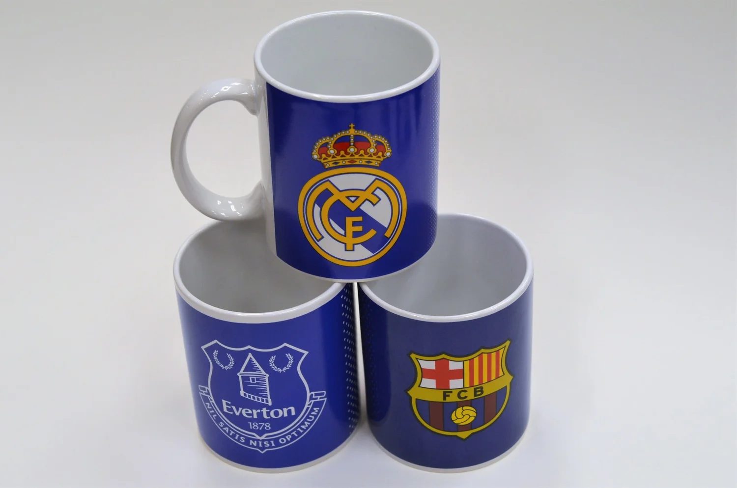 Three club mugs stacked: Real Madrid, Everton and FC Barcelona