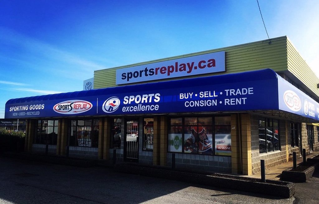 Sports Replay's storefront on the Langley Bypass, with a blue Sports Excellence awning reading Buy, Sell, Trade, Consign, Rent