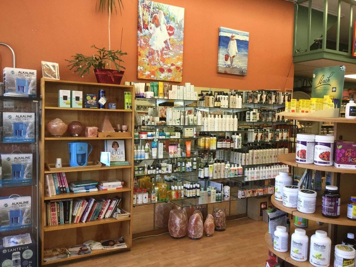 Body-care, natural cosmetics and supplement displays against an orange wall at Valley Natural Health