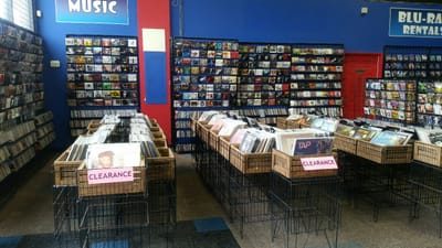 Inside Willow Video Games: racks of music CDs and records, Blu-ray rental shelves and bins of discs on clearance