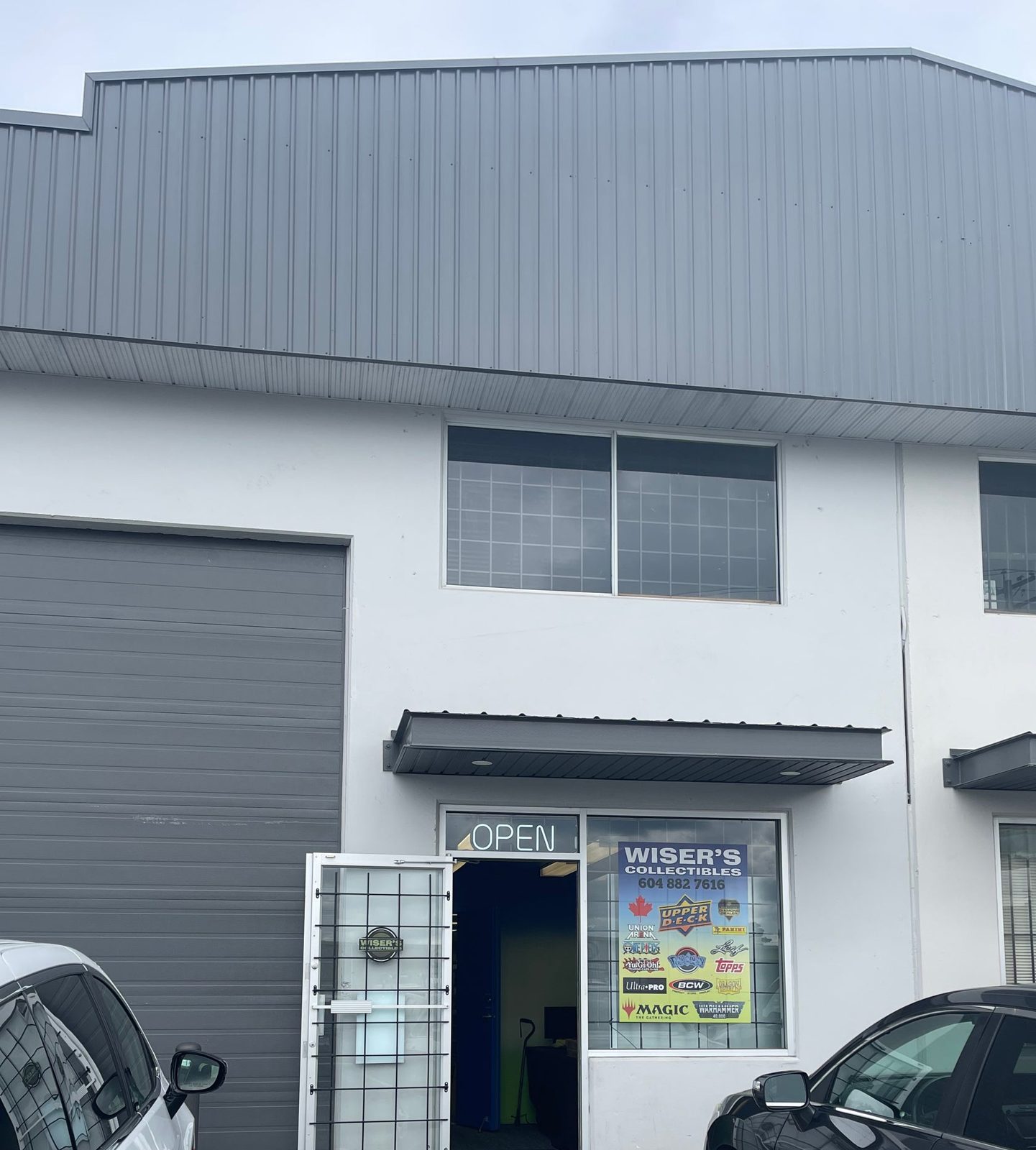 The Wiser's Collectibles storefront: an open door and a window poster of card brands in a grey industrial unit