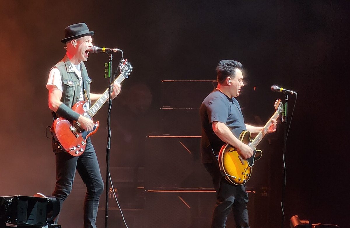 Gob performing at Caesars Windsor in 2023, a guitarist and bassist at the front of the stage under coloured lights