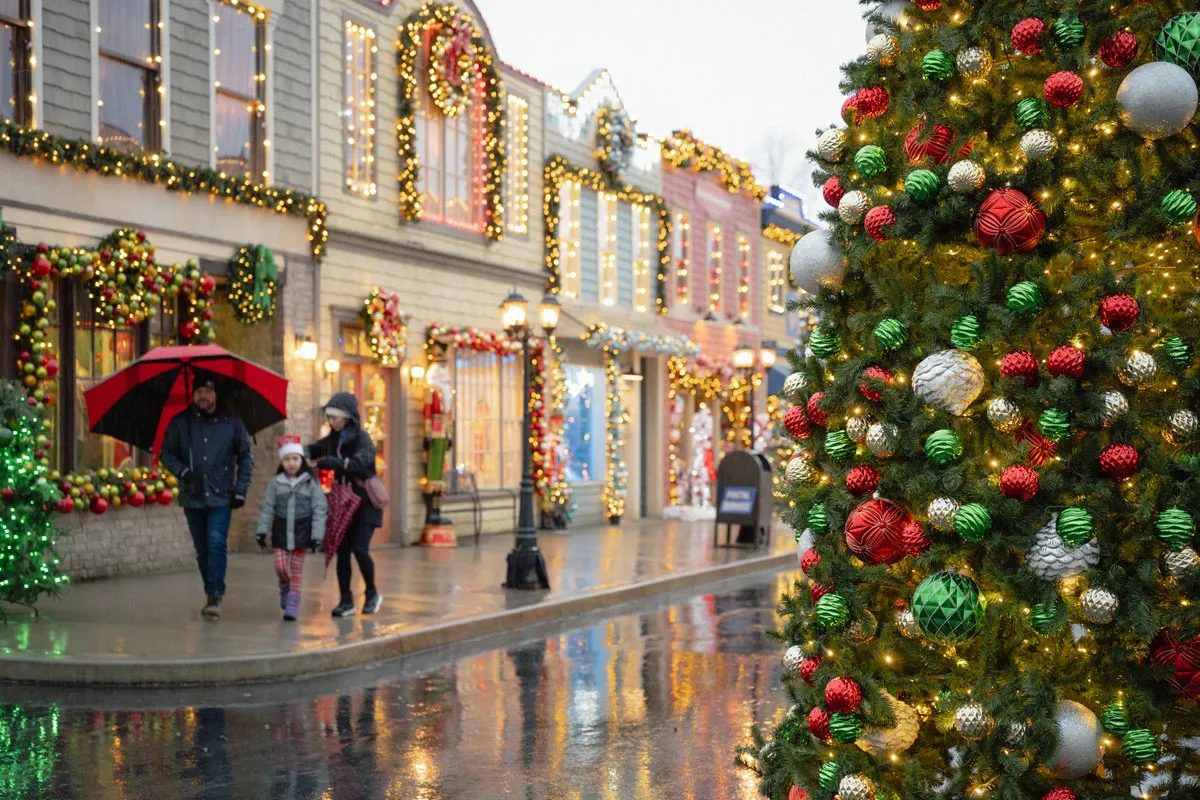 A decorated small-town street set with garlands and a big ornament-covered tree