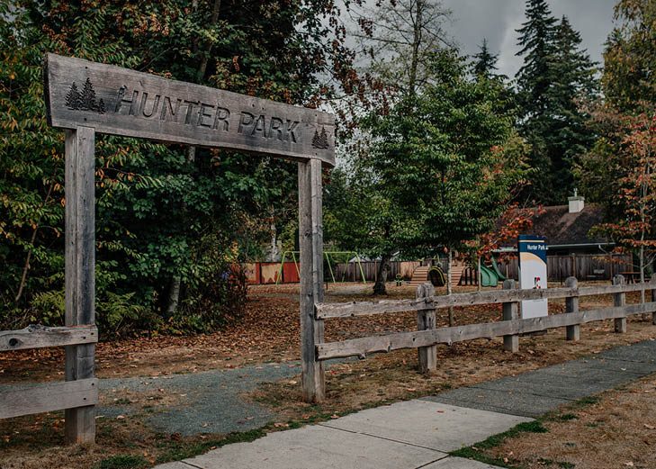 A Hunter Park sign beside a grassy area and trees in the Alice Brown area of Langley City