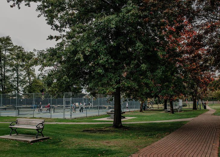 Douglas Park in Langley City with a playground, lawn and mature trees on a sunny day