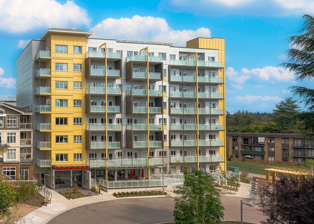 The Maple, a new nine-storey seniors' rental building with yellow and grey balconies behind the Langley Mall, Langley City