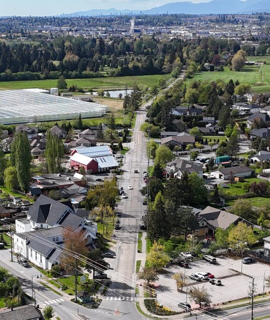 Aerial view of Old Yale Road running through the Five Corners area of Murrayville, with heritage buildings, a church and a greenhouse beside the road