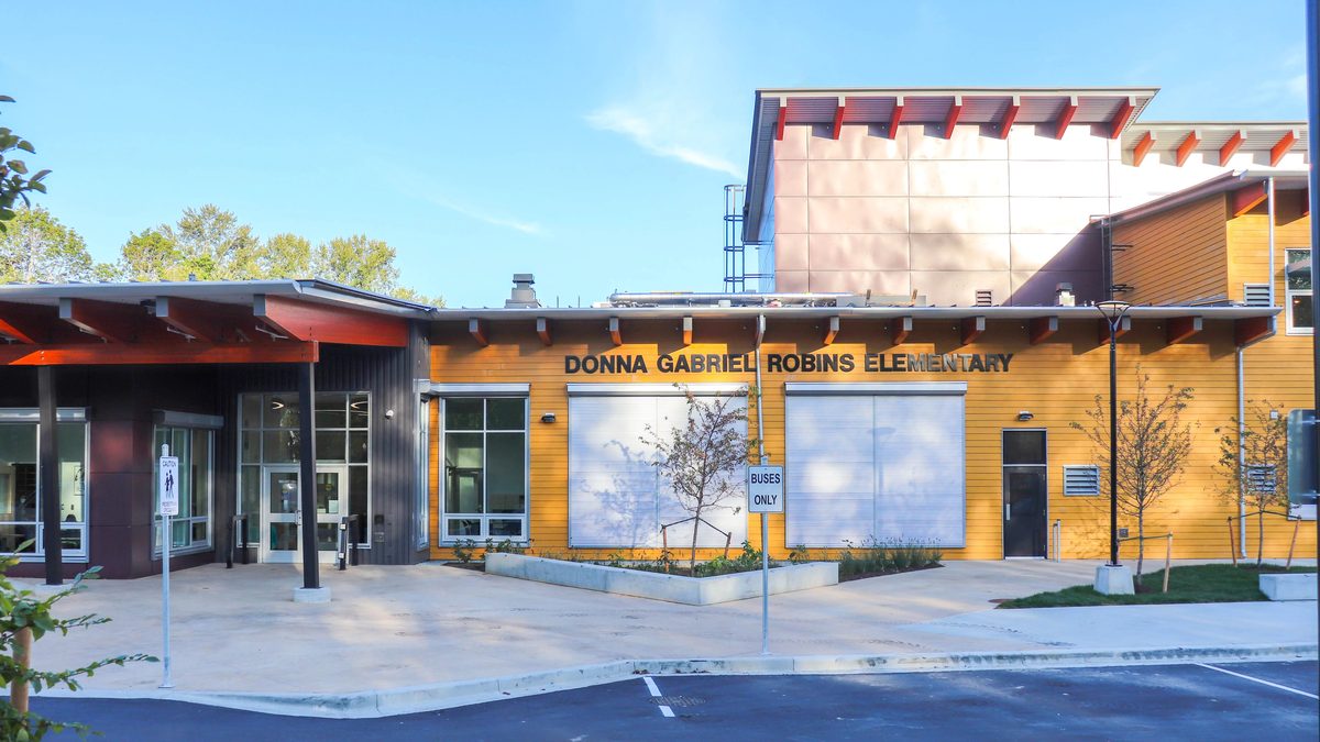 The front entrance of Donna Gabriel Robins Elementary School in Latimer, Willoughby, with its yellow cladding and red timber brackets