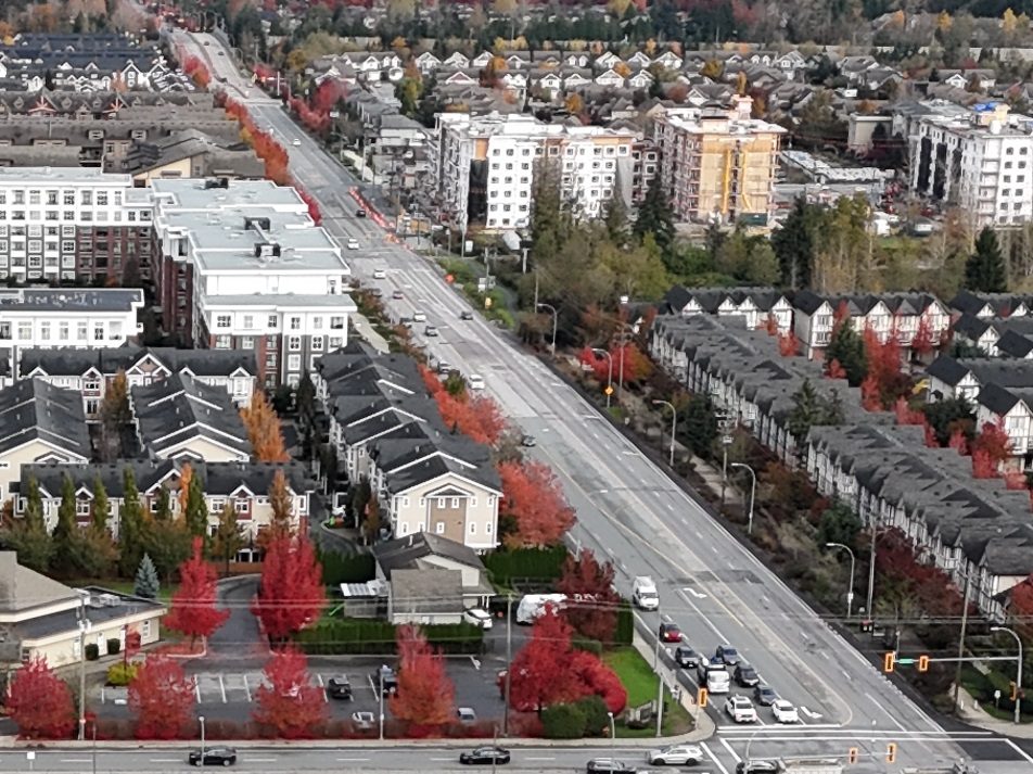 Aerial view of 208 Street through Yorkson, lined with townhouses