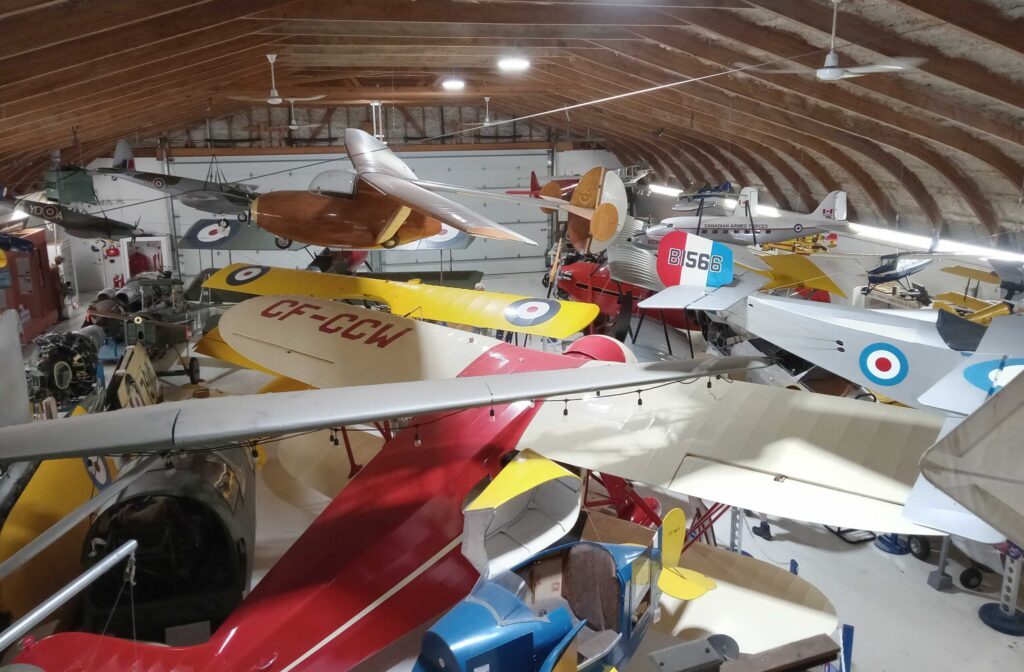 Inside the Canadian Museum of Flight's wooden-roofed hangar, packed wingtip to wingtip with yellow, red and silver vintage aircraft