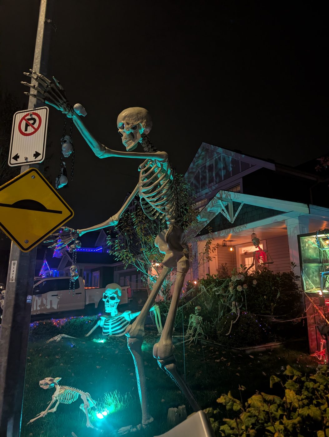 A giant skeleton reaching over the street sign